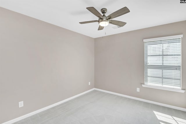 empty room featuring ceiling fan, baseboards, and light carpet