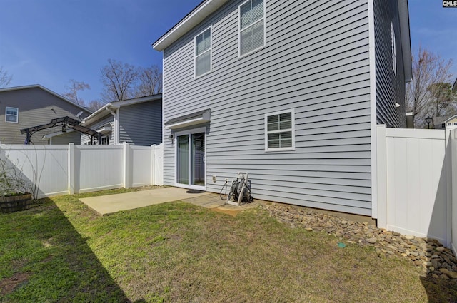 rear view of property featuring a patio area, a lawn, and fence