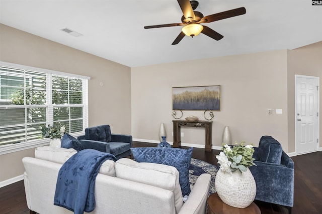 living area with visible vents, baseboards, dark wood-style floors, and ceiling fan