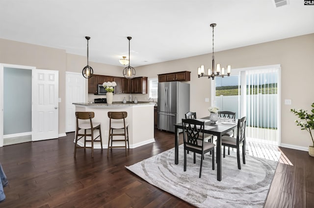 dining area featuring a notable chandelier, dark wood-style floors, and baseboards