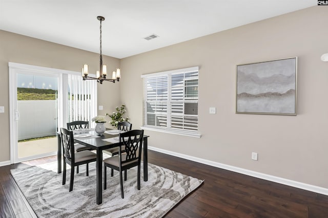 dining space with visible vents, baseboards, an inviting chandelier, and wood finished floors