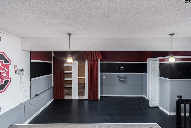 kitchen featuring baseboards, a textured ceiling, and wood finished floors