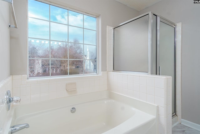 bathroom featuring a garden tub, marble finish floor, a shower stall, and a textured ceiling