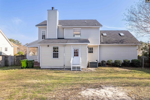 rear view of property with entry steps, cooling unit, a yard, and fence