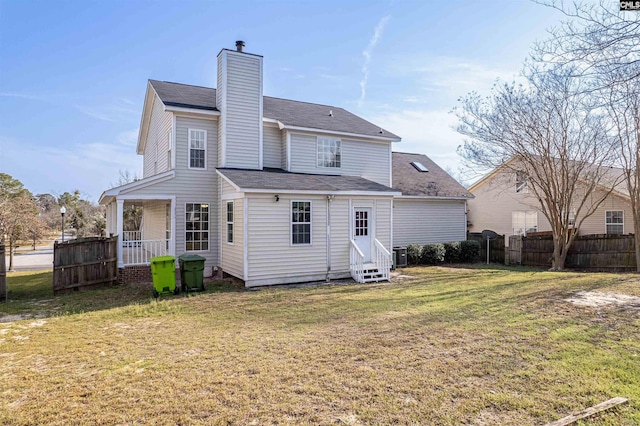 back of property with fence, a yard, a chimney, entry steps, and central air condition unit