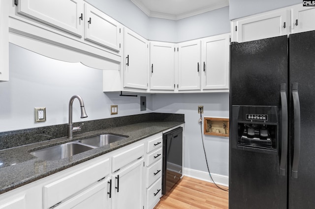 kitchen with light wood-style flooring, ornamental molding, a sink, black appliances, and white cabinets