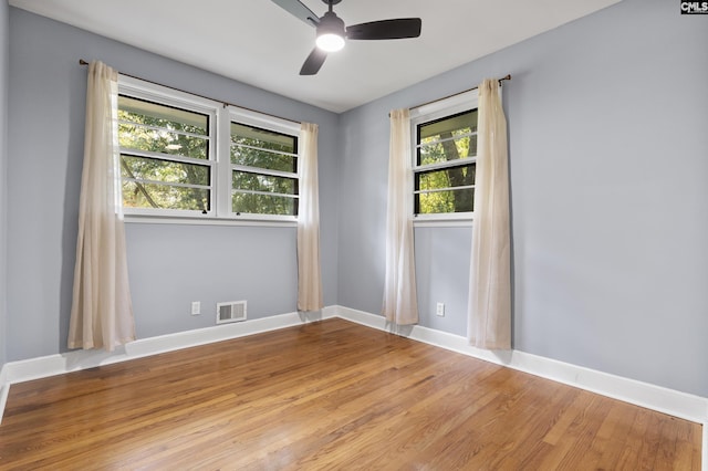 spare room featuring light wood-style flooring, baseboards, visible vents, and ceiling fan