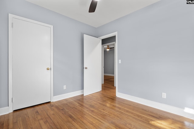 unfurnished bedroom featuring ceiling fan, baseboards, and wood finished floors