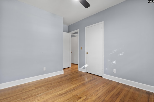 unfurnished bedroom featuring light wood-style flooring, a ceiling fan, and baseboards