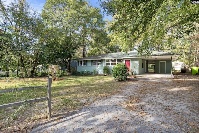 single story home featuring a front yard, an attached carport, and dirt driveway