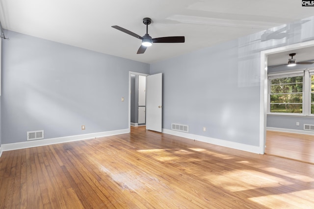 unfurnished room with hardwood / wood-style floors, visible vents, baseboards, and ceiling fan