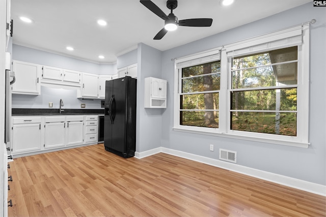 kitchen featuring a sink, visible vents, black appliances, and white cabinets