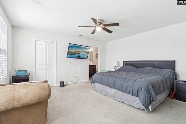 bedroom with visible vents, ensuite bathroom, a closet, carpet flooring, and ceiling fan