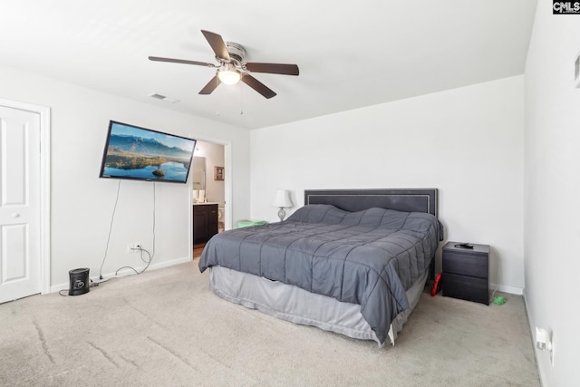 carpeted bedroom featuring baseboards, visible vents, ensuite bath, and ceiling fan