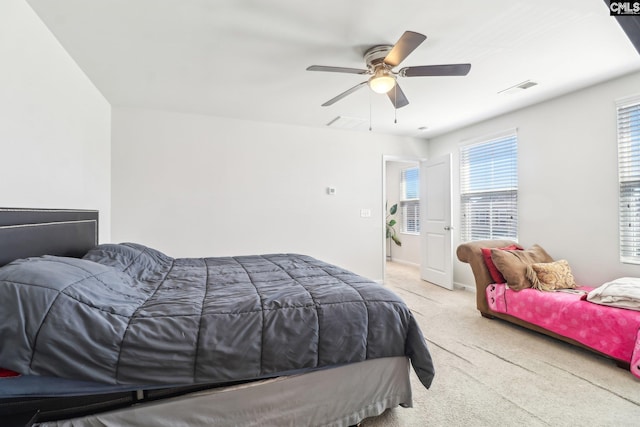 carpeted bedroom featuring a ceiling fan and visible vents