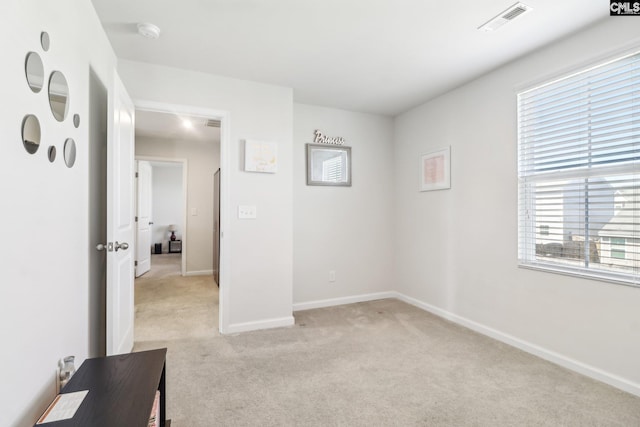 unfurnished bedroom featuring visible vents, baseboards, and light colored carpet