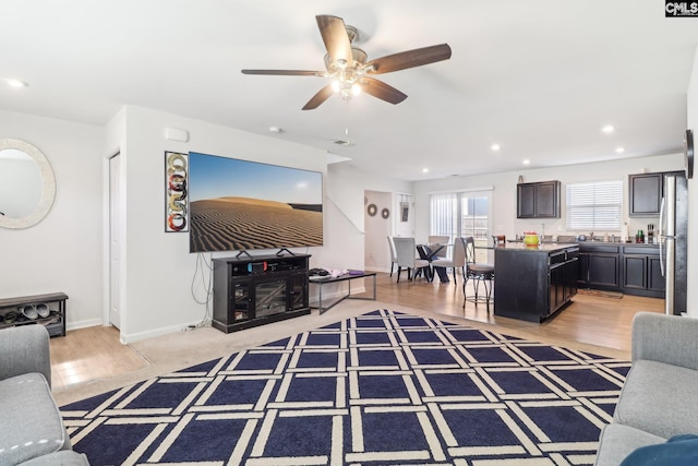 living room featuring recessed lighting, light wood-style flooring, baseboards, and ceiling fan