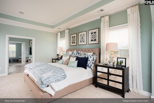 carpeted bedroom featuring a tray ceiling, baseboards, visible vents, and ornamental molding