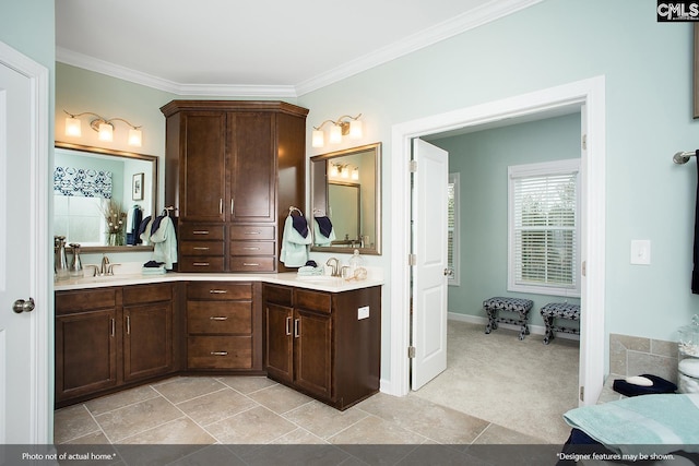 full bath with double vanity, ornamental molding, baseboards, and a sink