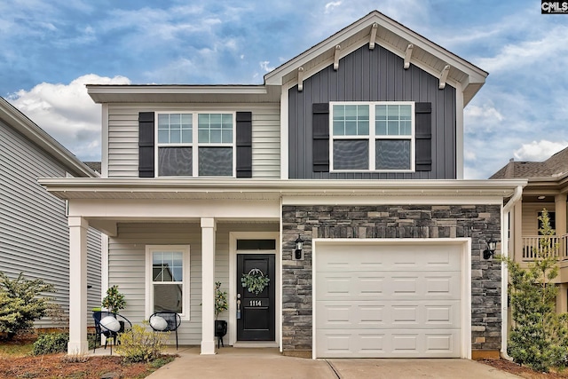 view of front of property featuring a porch, stone siding, driveway, and an attached garage