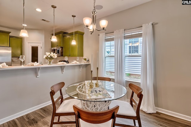 dining room with a wealth of natural light, visible vents, baseboards, and dark wood finished floors