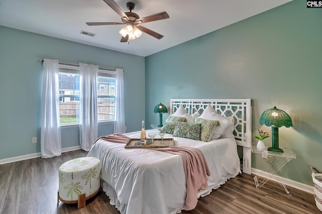 bedroom with visible vents, baseboards, and wood finished floors