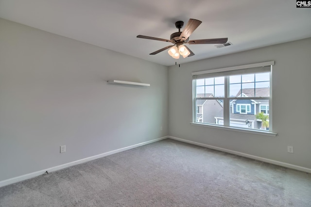 spare room featuring ceiling fan, carpet, visible vents, and baseboards