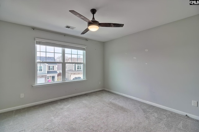 empty room featuring visible vents, carpet flooring, baseboards, and ceiling fan