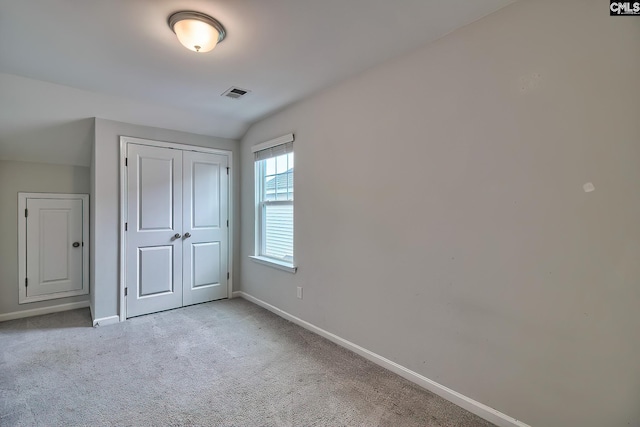 unfurnished bedroom featuring a closet, visible vents, baseboards, and carpet