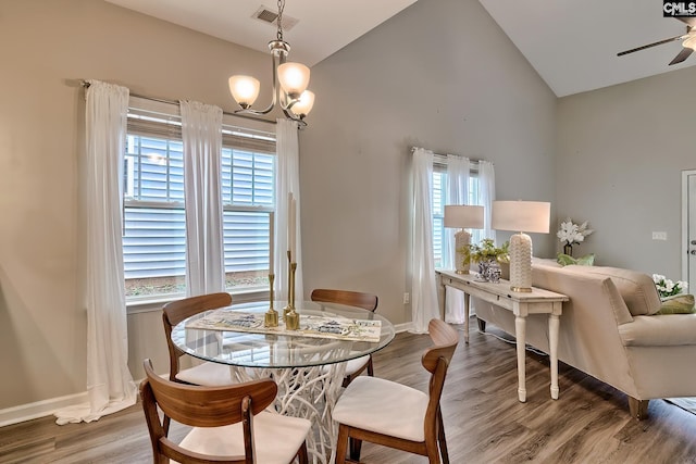 dining space featuring vaulted ceiling, plenty of natural light, wood finished floors, and visible vents