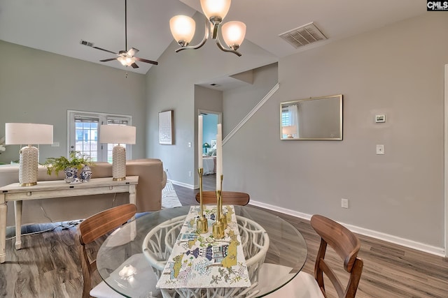 dining area with wood finished floors, ceiling fan with notable chandelier, visible vents, and baseboards