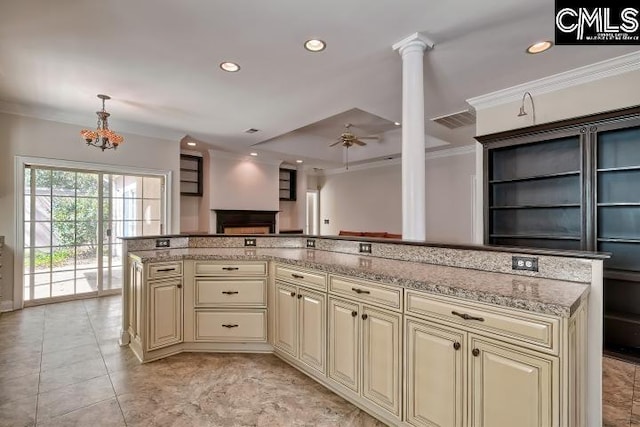 kitchen with light stone countertops, recessed lighting, cream cabinetry, crown molding, and ceiling fan with notable chandelier