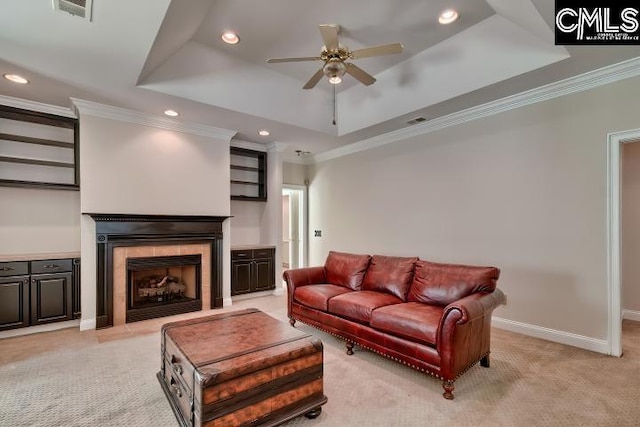 living room with visible vents, baseboards, a tray ceiling, light carpet, and a ceiling fan