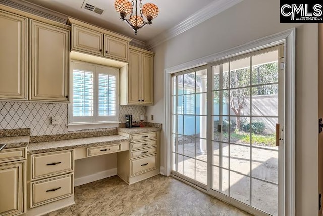 kitchen featuring visible vents, cream cabinetry, crown molding, decorative backsplash, and built in study area