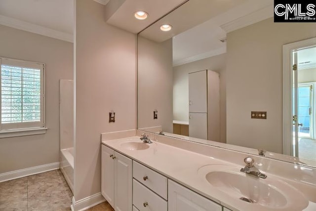 full bathroom featuring double vanity, ornamental molding, baseboards, and a sink