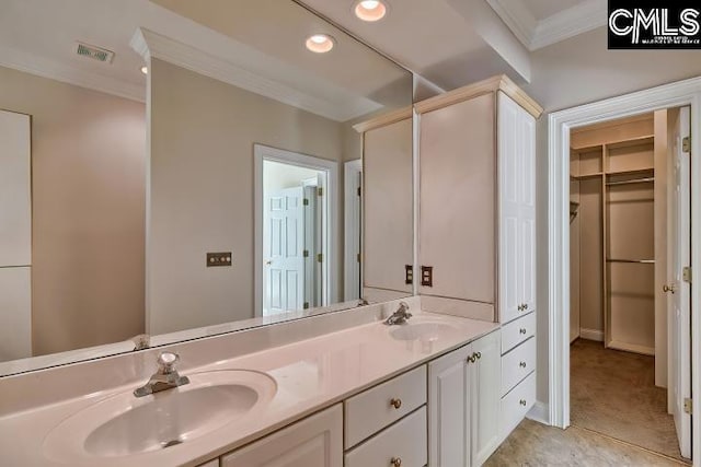 bathroom with double vanity, visible vents, crown molding, and a sink