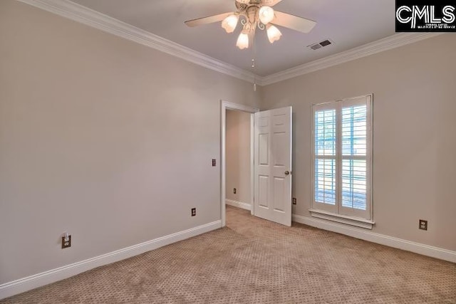 spare room featuring ceiling fan, ornamental molding, visible vents, and light carpet