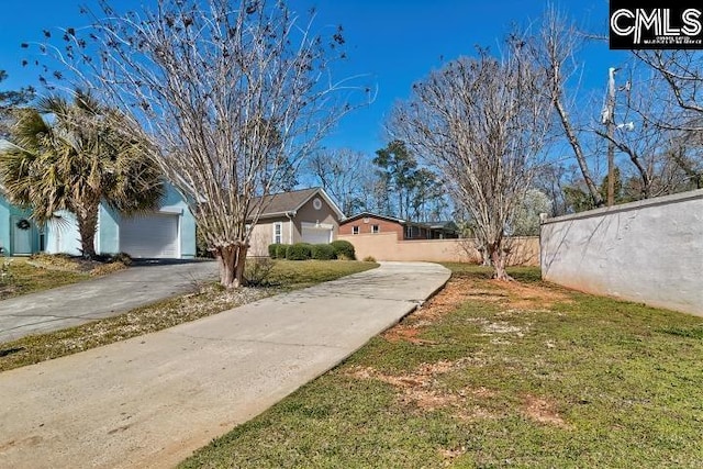 exterior space with driveway, a garage, and fence