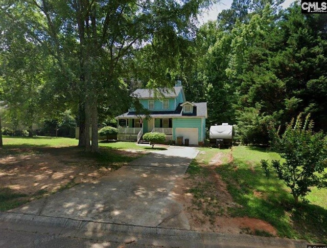 view of front of home featuring a front yard, covered porch, and driveway