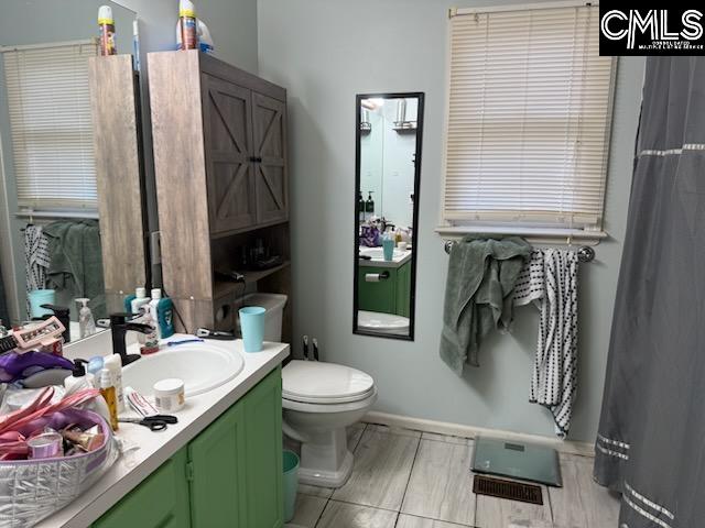 bathroom featuring vanity, toilet, and baseboards