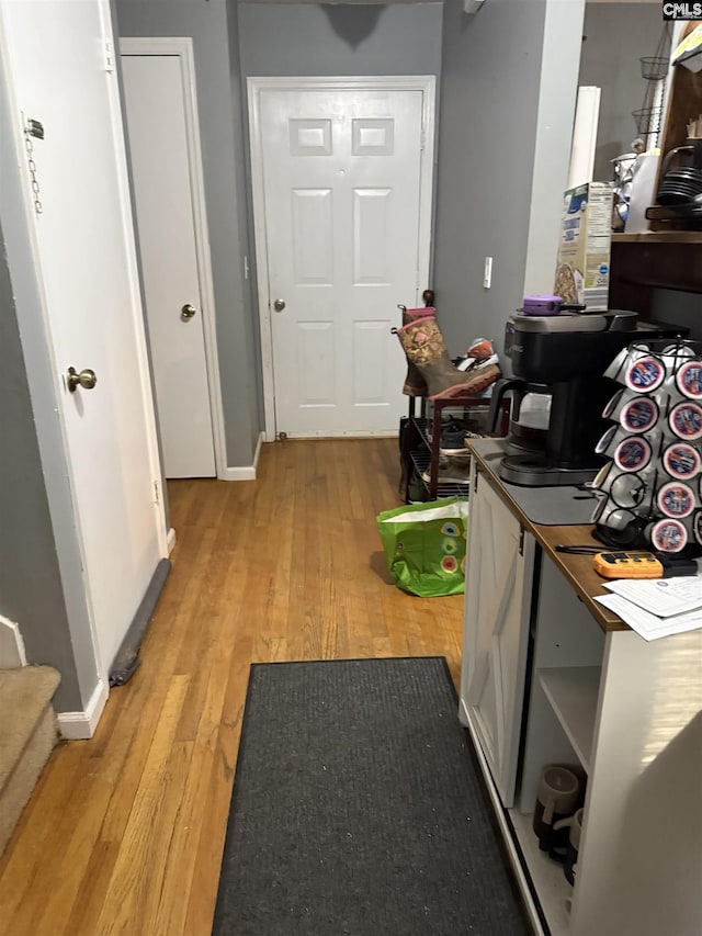 hallway with light wood-style flooring and baseboards