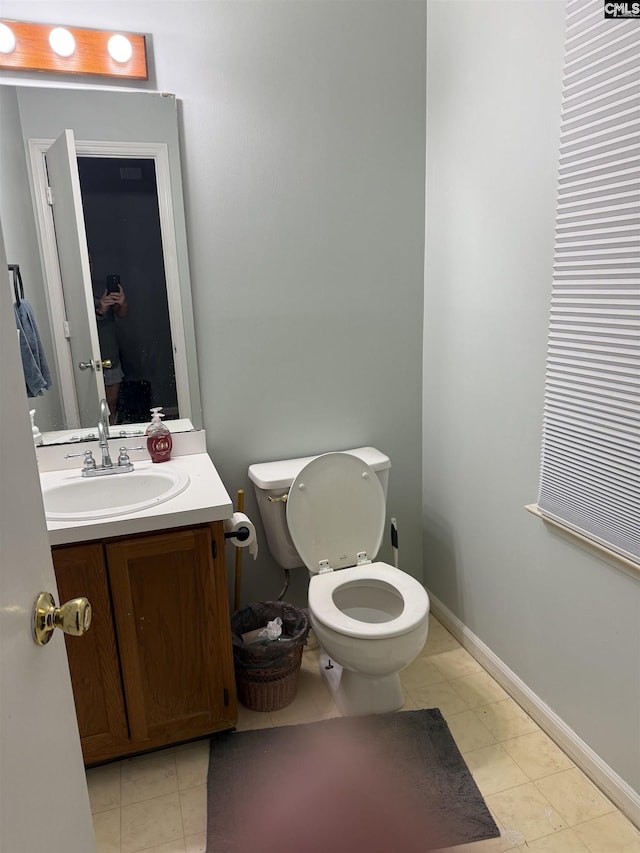 bathroom with vanity, toilet, and baseboards