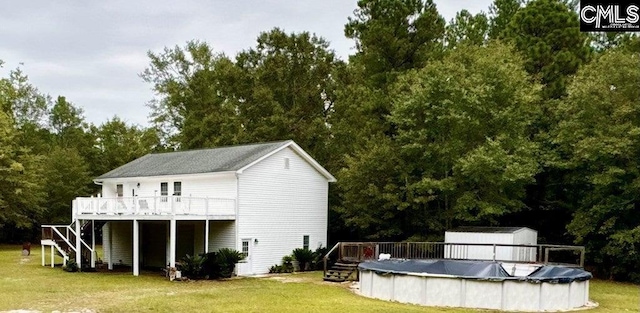 back of property with a yard, stairs, and a deck