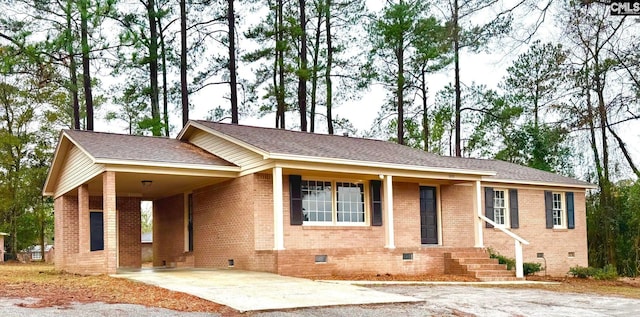 single story home featuring a carport, brick siding, driveway, and crawl space