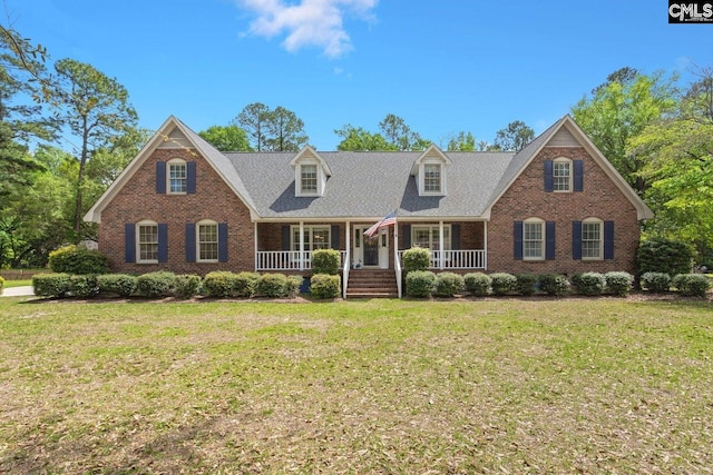 view of front of house with brick siding, a porch, and a front lawn