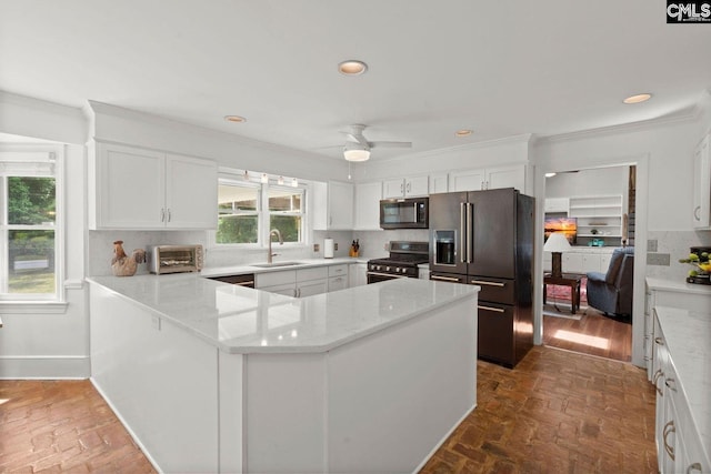 kitchen with crown molding, a toaster, decorative backsplash, brick floor, and stainless steel appliances