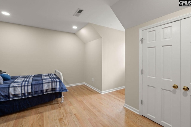 bedroom with visible vents, lofted ceiling, recessed lighting, light wood-style floors, and baseboards