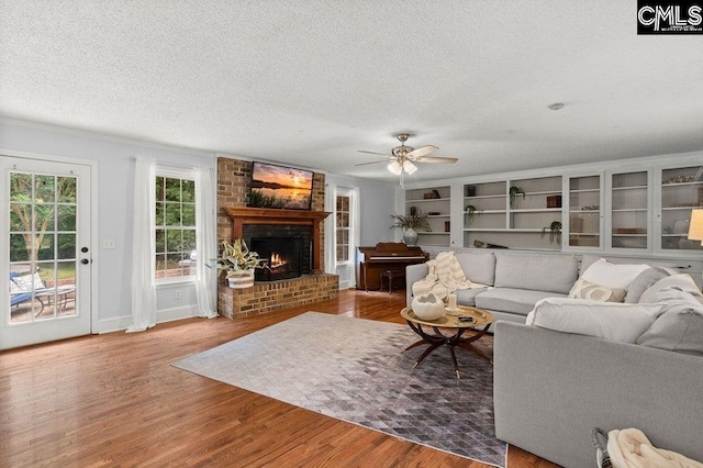 living area featuring a textured ceiling, a ceiling fan, and wood finished floors