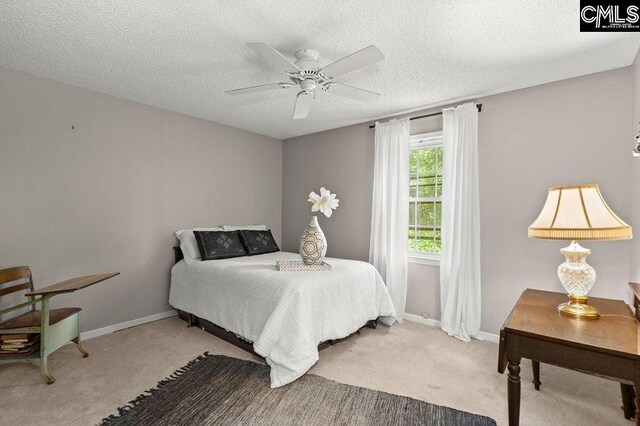 bedroom with baseboards, a textured ceiling, and carpet flooring