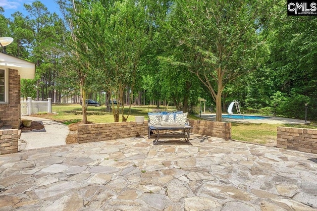 view of patio with fence and an outdoor pool